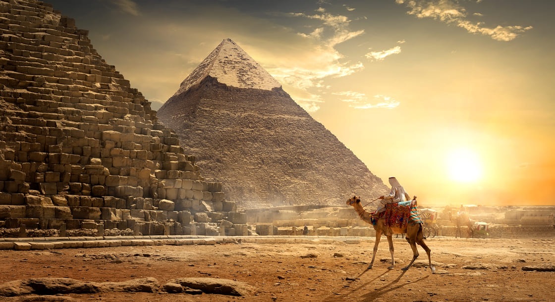  Nomade auf Kamel in der Nähe von Pyramiden in der ägyptischen Wüste